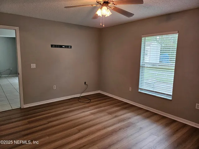 an empty room with wooden floor and windows