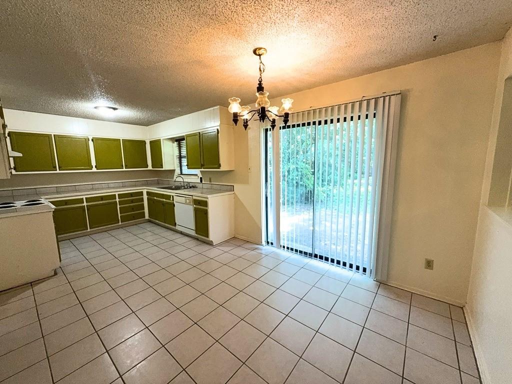 1613 Edgehill Road Benbrook, TX 76126 - Photo 5 of 22 a kitchen with stainless steel appliances a refrigerator and microwave