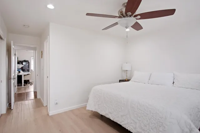 a bedroom with a bed and a ceiling fan