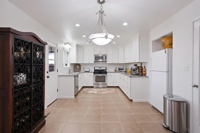 a kitchen with white cabinets and white appliances