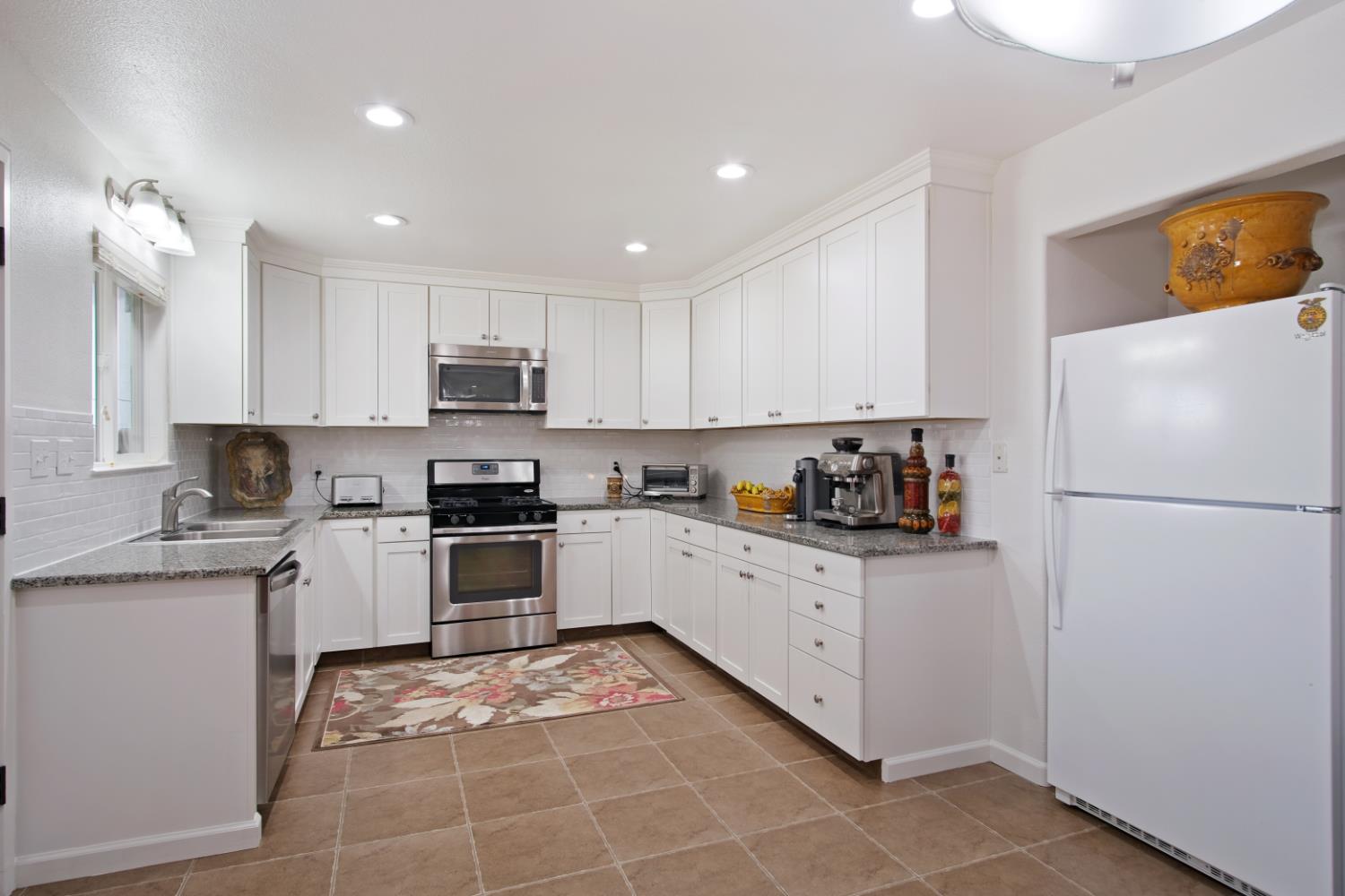 1921 Carleton Drive Turlock, CA 95382 - Photo 7 of 26 a kitchen with granite countertop a refrigerator and a stove top oven
