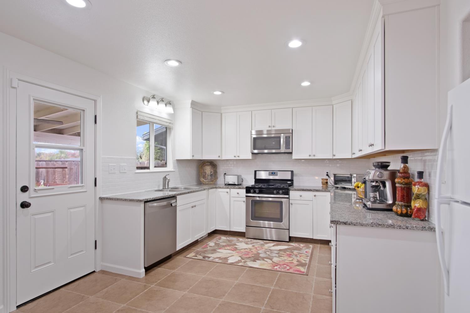 1921 Carleton Drive Turlock, CA 95382 - Photo 8 of 26 a kitchen with stainless steel appliances granite countertop a sink and stove top oven