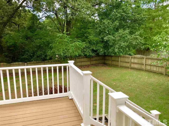 a balcony with wooden floor and yard