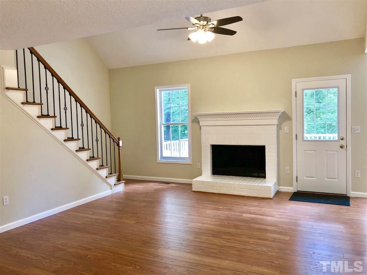 2825 Glastonbury Road Apex, NC 27539 - Photo 3 of 21 a view of an empty room with wooden floor fireplace and a window