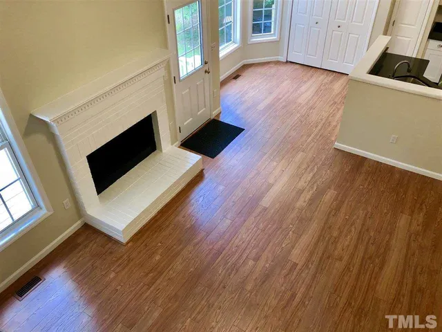 a living room with wooden floors and a fireplace