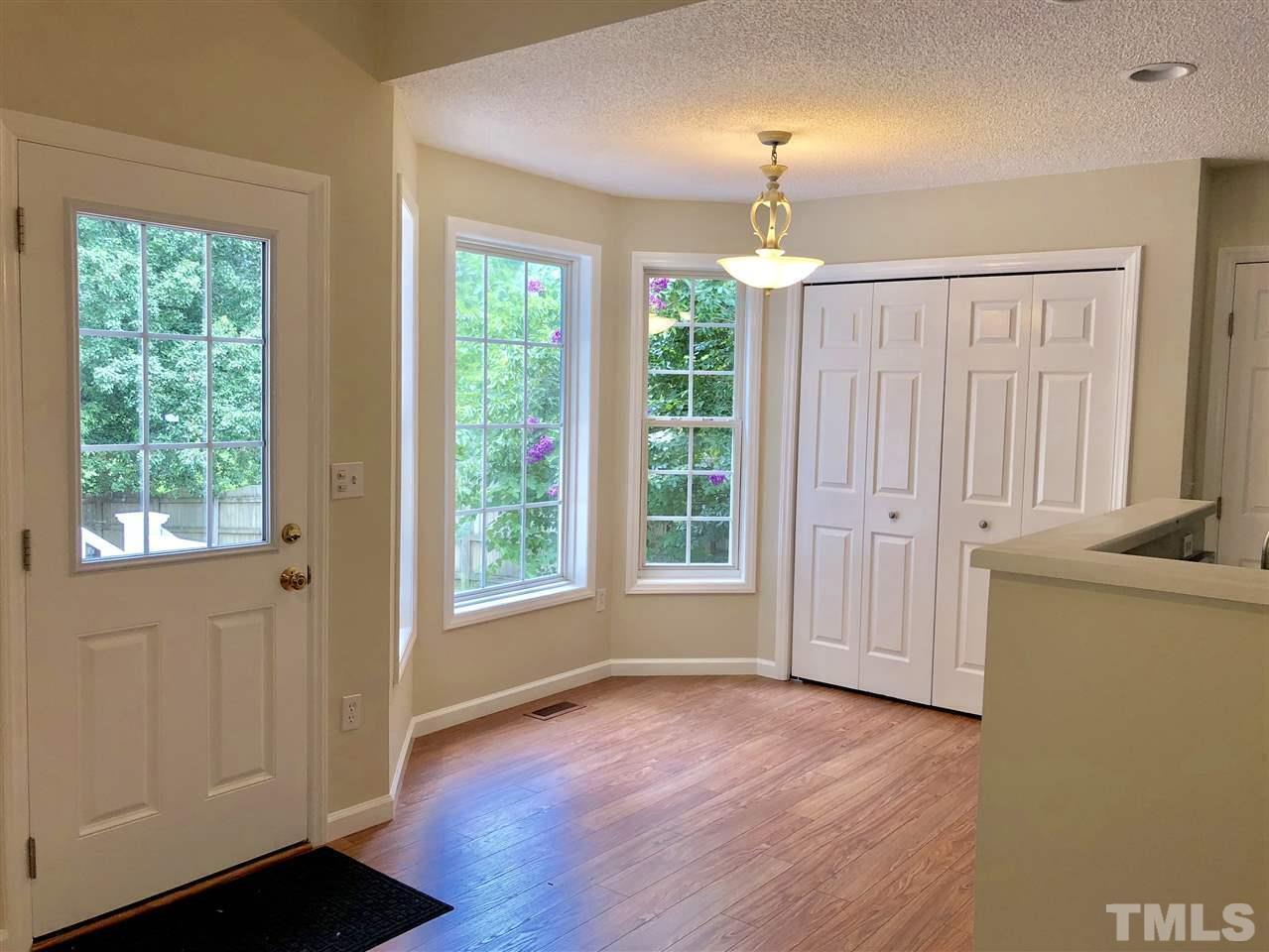 2825 Glastonbury Road Apex, NC 27539 - Photo 6 of 21 a view of an empty room with a window and wooden floor