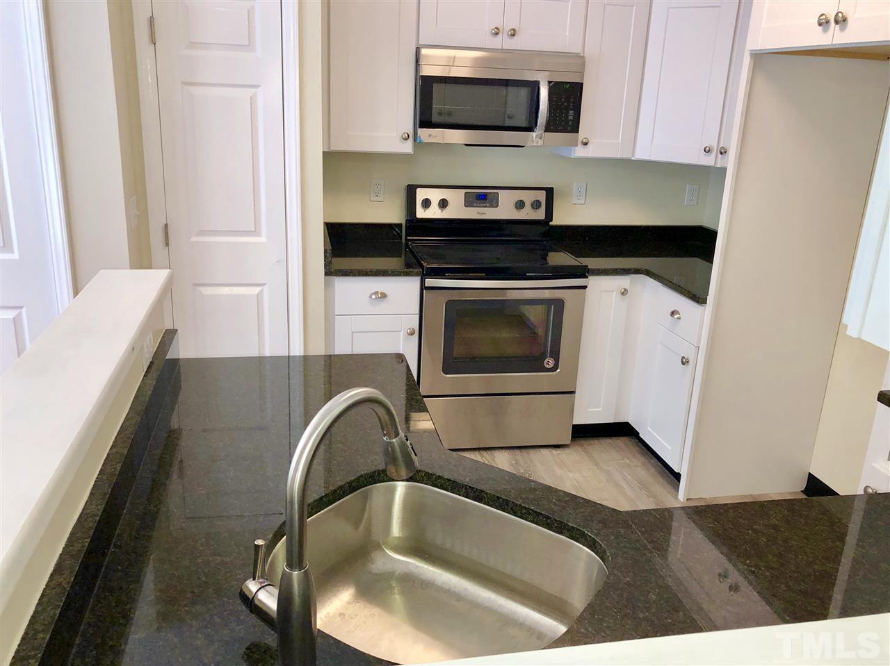 2825 Glastonbury Road Apex, NC 27539 - Photo 9 of 21 a kitchen with a sink and a stove top oven with wooden floor