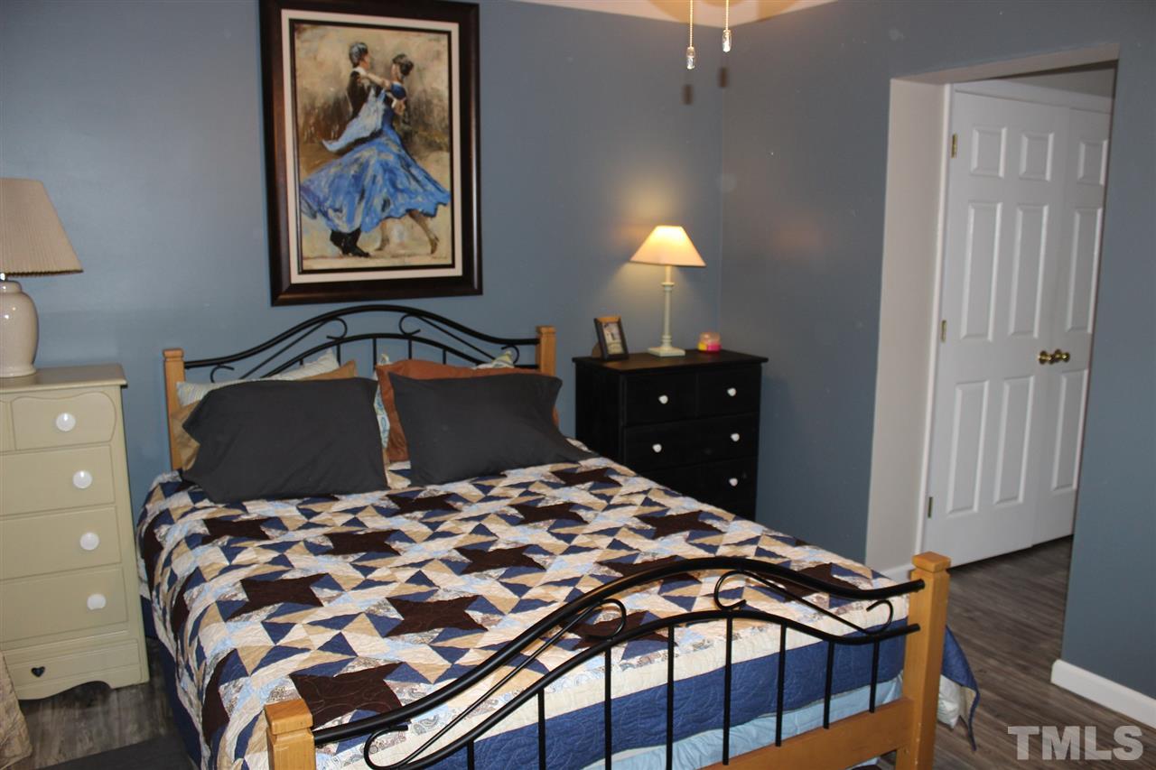 462 Pixley Pritchard Road Timberlake, NC 27583 - Photo 12 of 25 a bedroom with a bed and a lamp on dresser