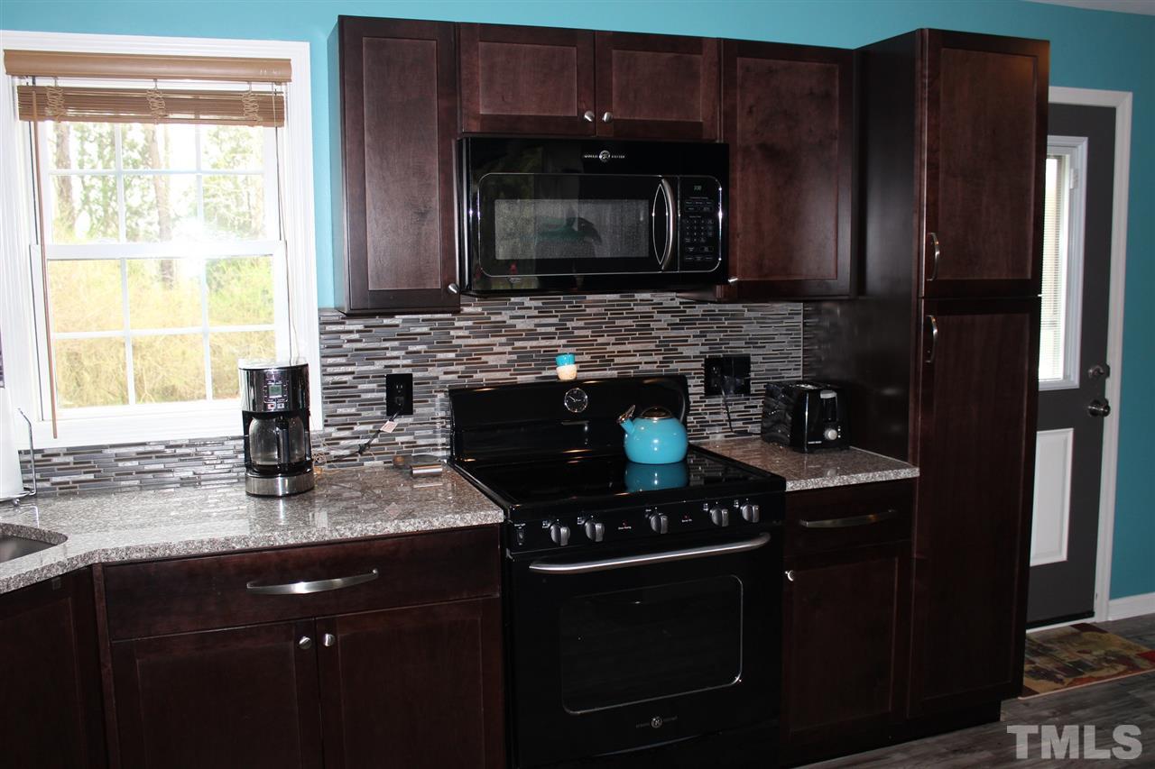 462 Pixley Pritchard Road Timberlake, NC 27583 - Photo 6 of 25 a kitchen with stainless steel appliances granite countertop a stove a microwave a sink and a refrigerator