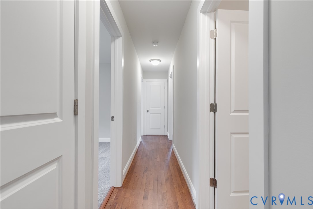 339 Midway Lane Aylett, VA 23009 - Photo 22 of 31 a view of a hallway with wooden floor and a bathroom