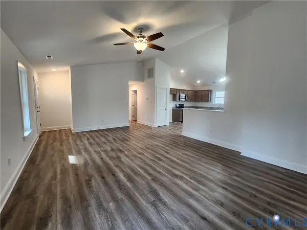 a view of empty room with wooden floor