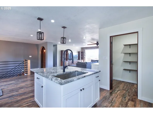 a kitchen view with granite countertop a sink stainless steel appliances and cabinets