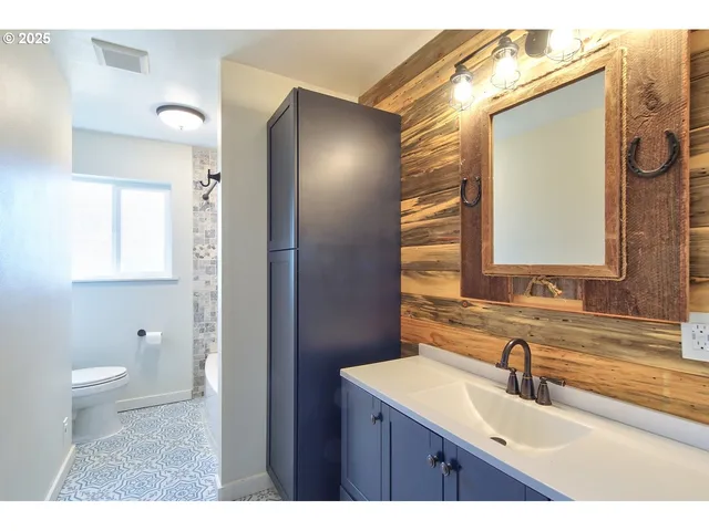 a bathroom with a sink a toilet and a mirror
