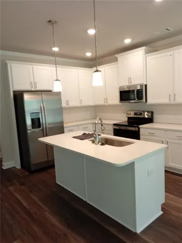 a kitchen with kitchen island a sink a stove a refrigerator and a microwave