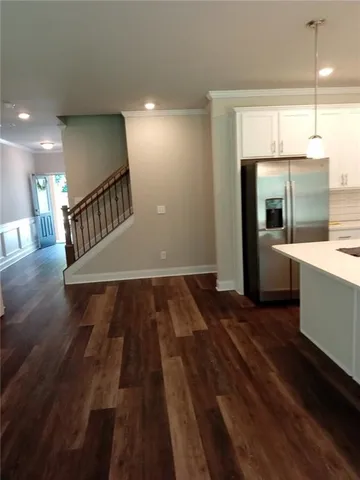 a view of a kitchen with kitchen island a sink wooden floor and a window
