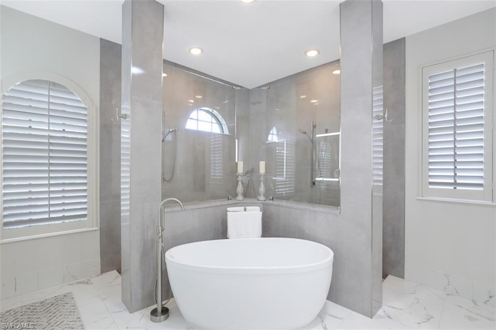 7323 Acorn Way Naples, FL 34119 - Photo 17 of 28 Double walk in shower, a freestanding bath, and recessed lighting