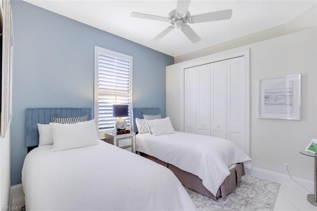7323 Acorn Way Naples, FL 34119 - Photo 18 of 28 Bedroom featuring a large closet, ceiling fan, and tile flooring