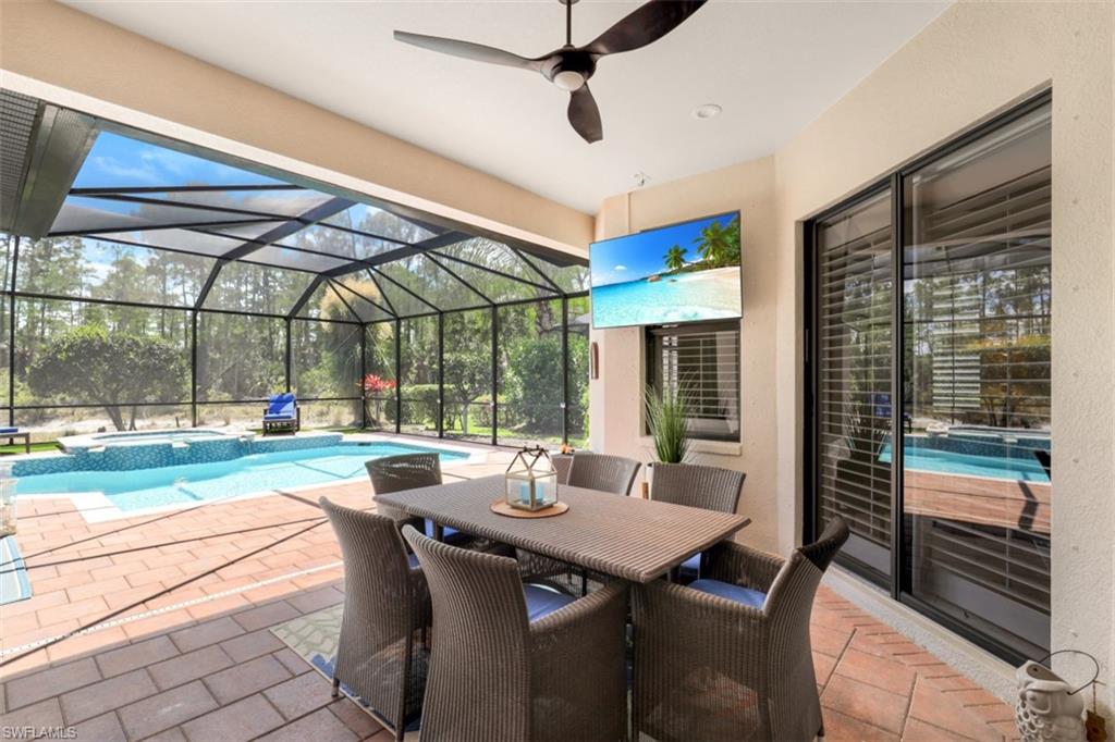 7323 Acorn Way Naples, FL 34119 - Photo 3 of 28 View of patio / terrace with a pool with connected hot tub, screened enclosure and outdoor dining space