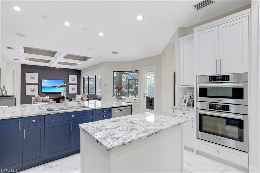 7323 Acorn Way Naples, FL 34119 - Photo 28 of 28 Kitchen featuring stainless steel appliances, a center island, open floor plan, recessed lighting, and light stone countertops