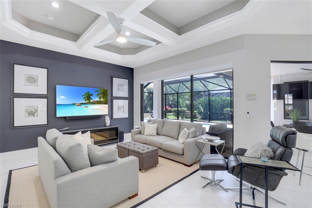 7323 Acorn Way Naples, FL 34119 - Photo 8 of 28 Living area, a ceiling fan, coffered ceiling, marble look tiles, and recessed lighting