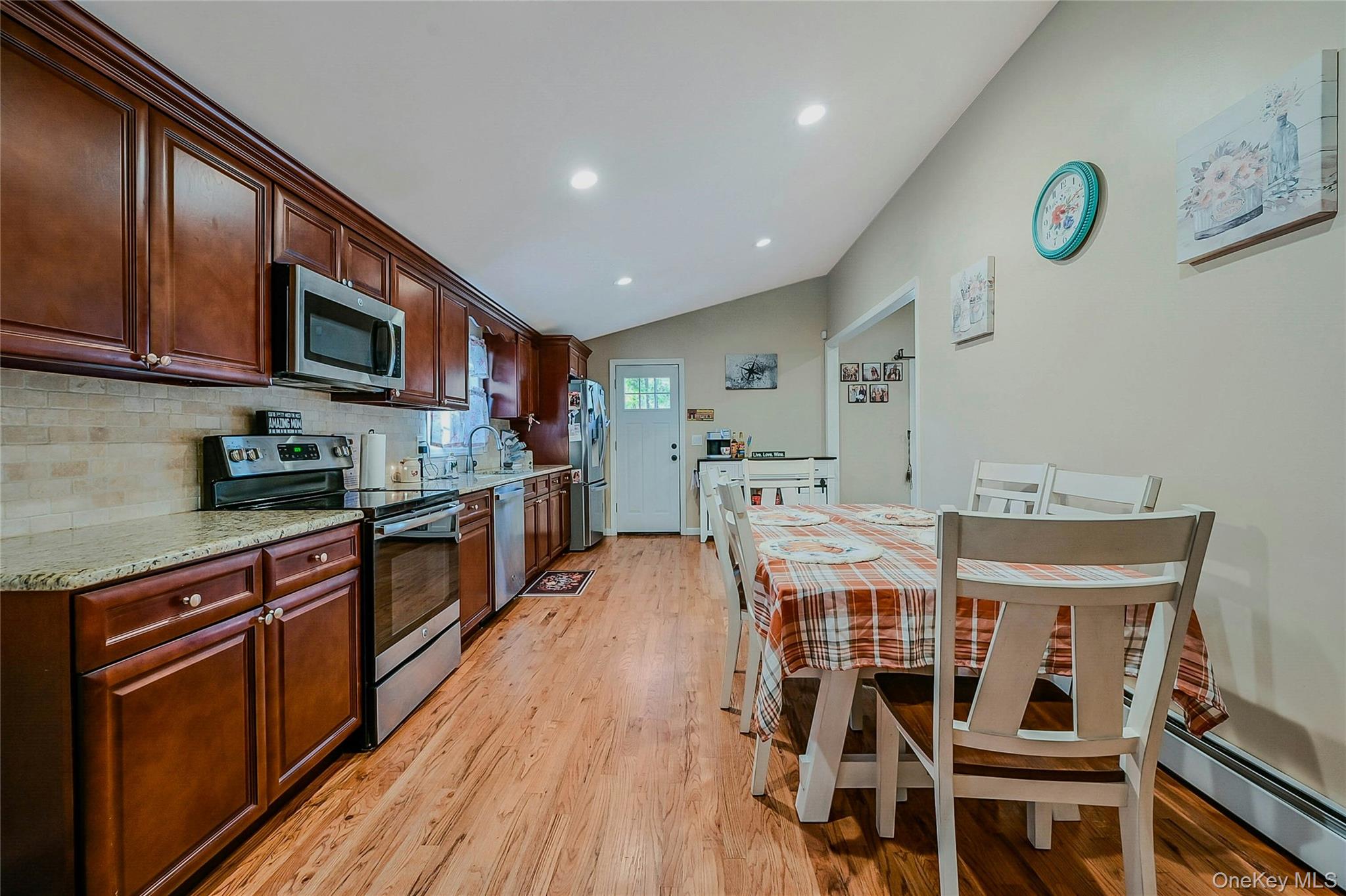 196 Church Drive Mastic Beach, NY 11951 - Photo 3 of 15 a kitchen with stainless steel appliances granite countertop a kitchen island hardwood floor sink stove dining table and chairs