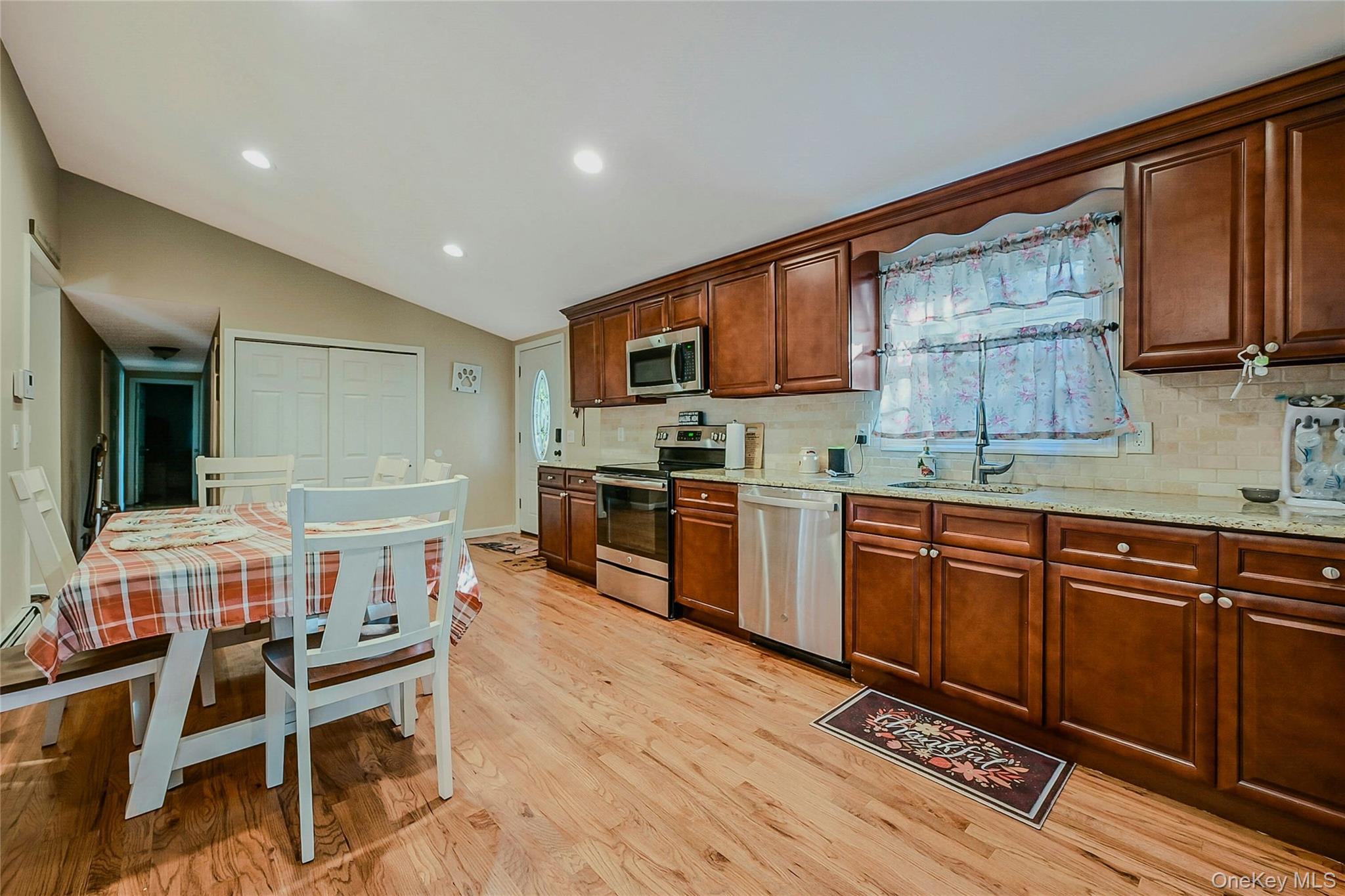 196 Church Drive Mastic Beach, NY 11951 - Photo 4 of 15 a open kitchen with stainless steel appliances granite countertop a stove top oven a sink dishwasher and cabinets with wooden floor