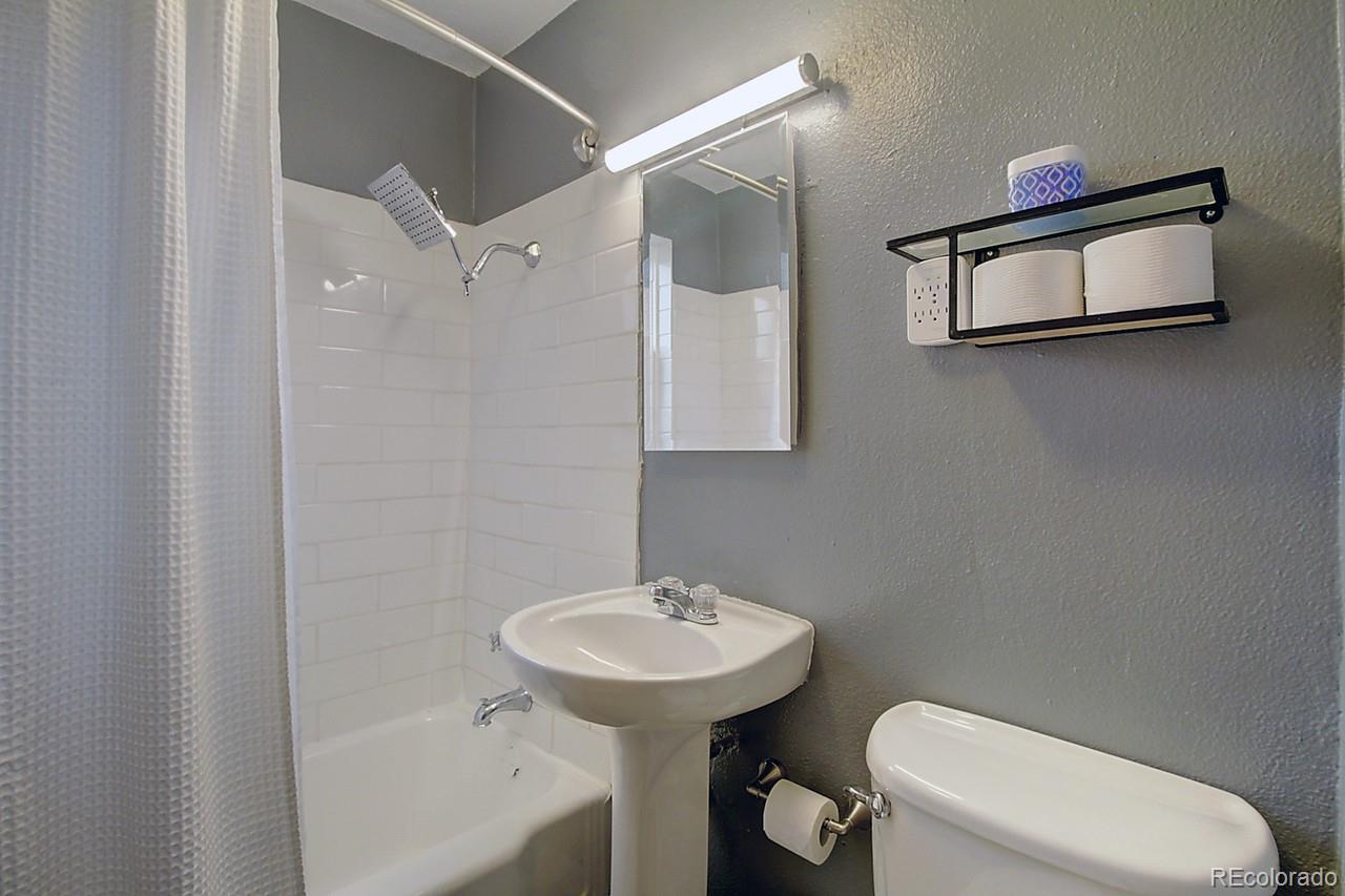 4075 Quay Street Wheat Ridge, CO 80033 - Photo 17 of 38 a bathroom with a sink a mirror and a toilet