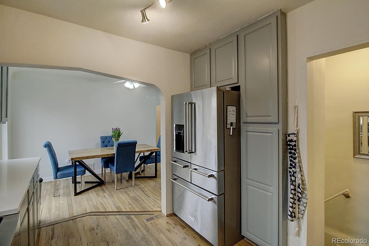4075 Quay Street Wheat Ridge, CO 80033 - Photo 28 of 38 a kitchen with stainless steel appliances refrigerator dining table and chairs