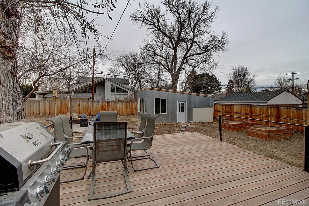 4075 Quay Street Wheat Ridge, CO 80033 - Photo 33 of 38 a view of a roof deck with table and chairs with wooden floor and fence