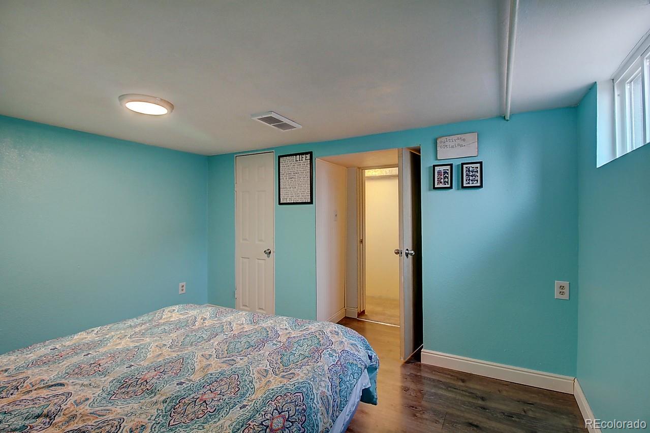4075 Quay Street Wheat Ridge, CO 80033 - Photo 10 of 38 a bedroom with a bed and wooden floor