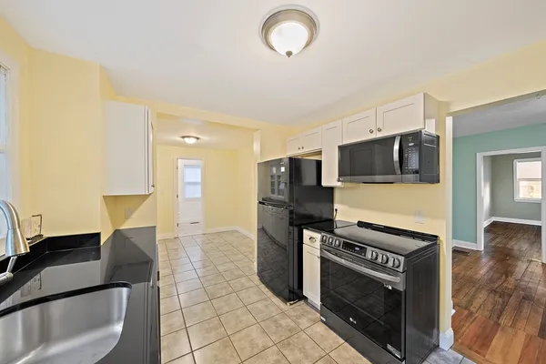 a kitchen with stainless steel appliances a stove microwave and sink