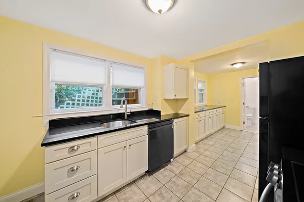 a kitchen with granite countertop white cabinets and white appliances