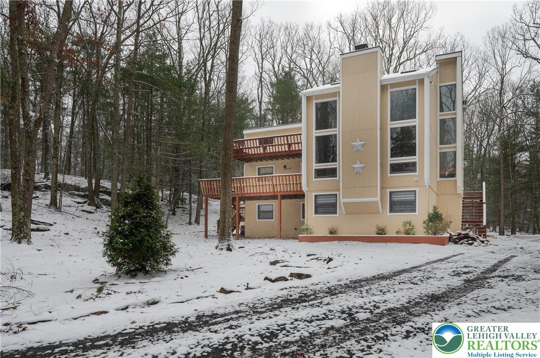 a front view of a house with a yard covered with snow