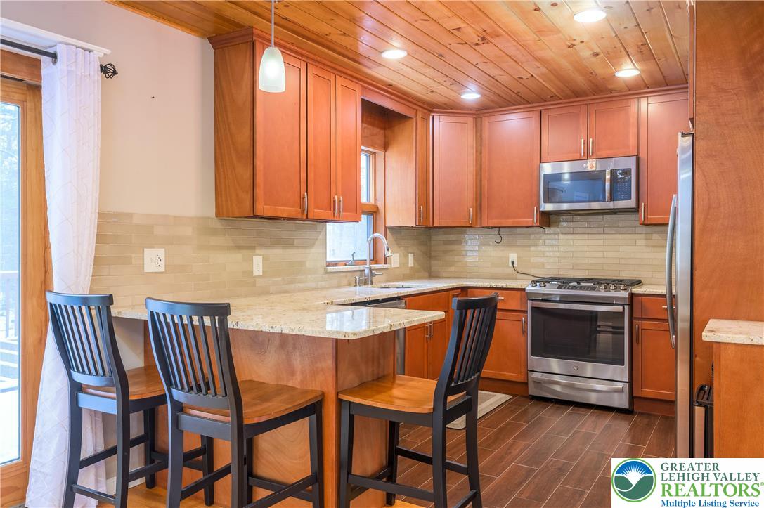 169 Shiny Mountain Road Greentown, PA 18426 - Photo 17 of 54 a kitchen with a table chairs cabinets and stainless steel appliances