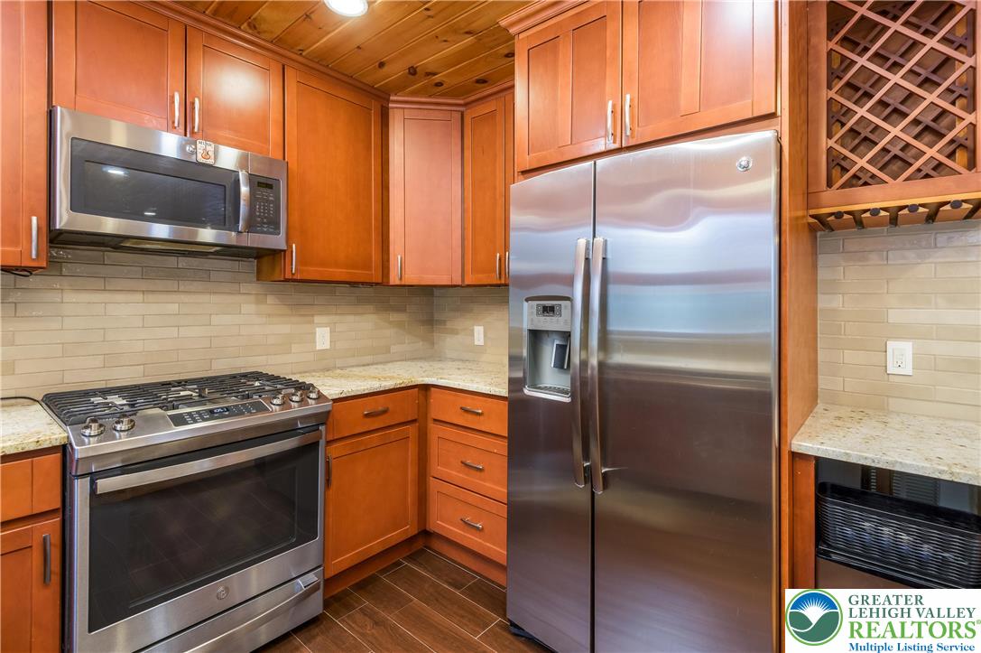 169 Shiny Mountain Road Greentown, PA 18426 - Photo 18 of 54 a kitchen with granite countertop a refrigerator stove and microwave