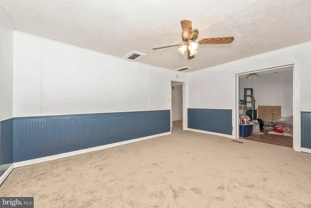 an empty room with closet and ceiling fan