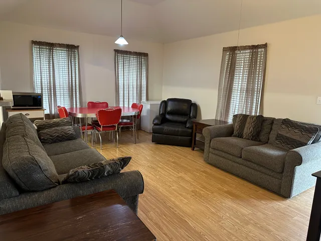 a living room with furniture and wooden floor
