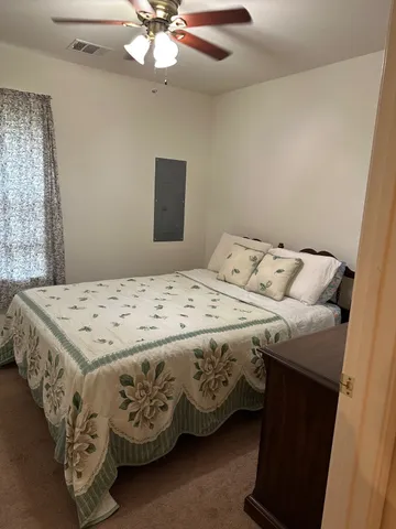 a bedroom with a bed and a chandelier