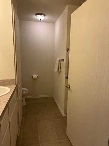 a bathroom with a granite countertop shower and a toilet