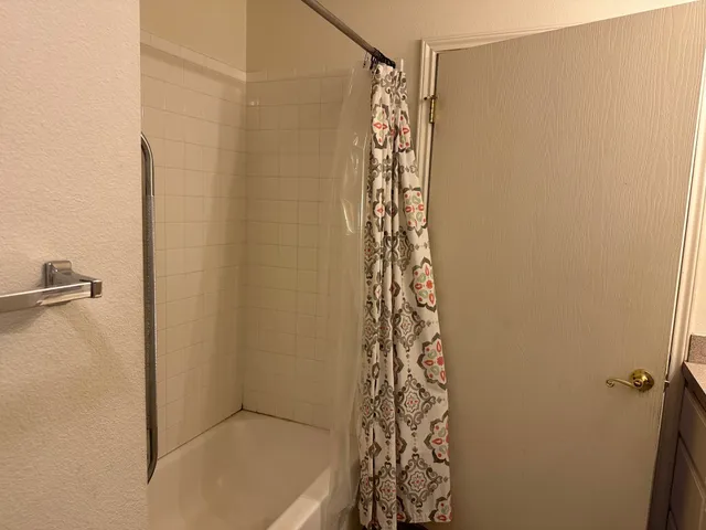 a bathroom with a shower curtain and a window