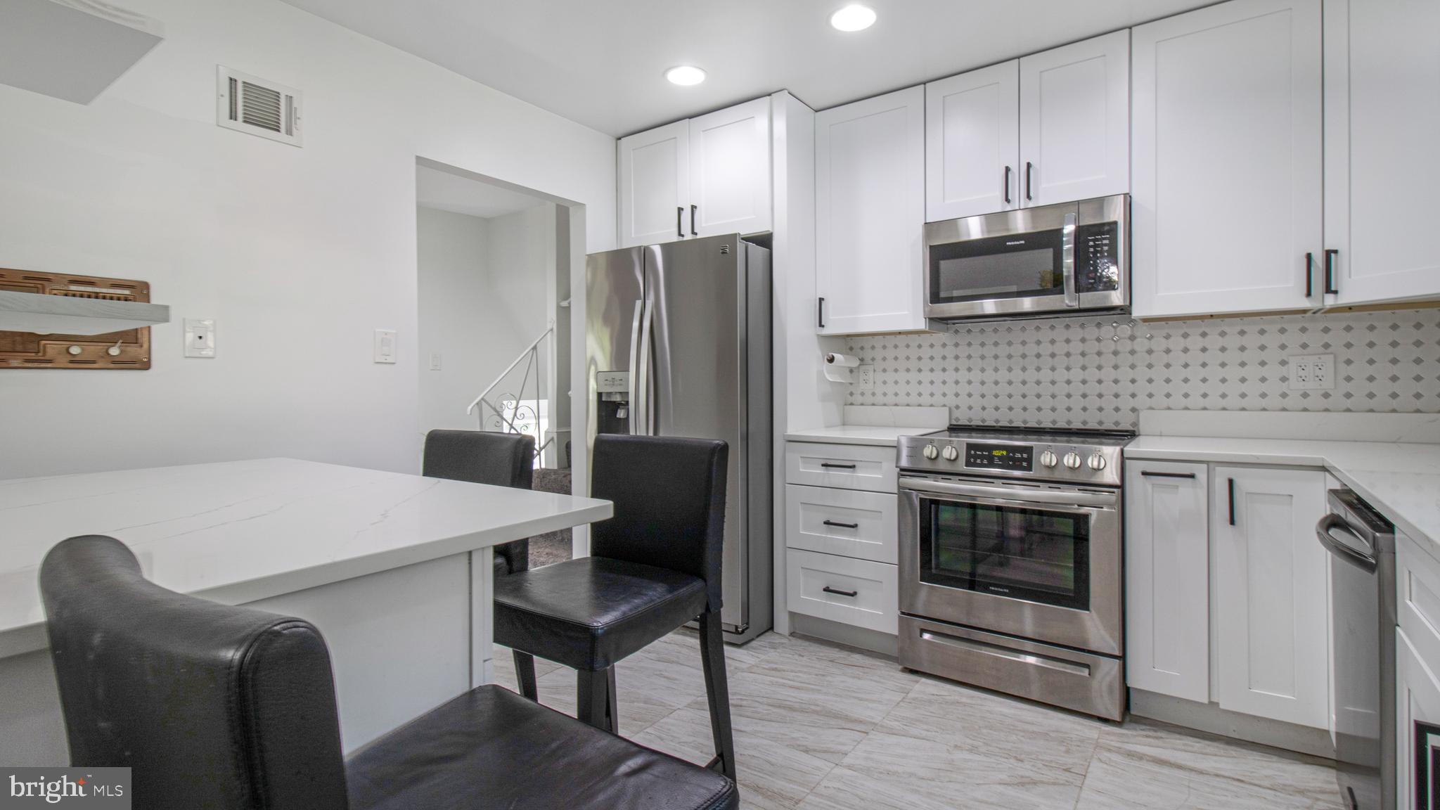 10310 Royal Road Silver Spring, MD 20903 - Photo 17 of 61 a kitchen with stainless steel appliances a stove microwave and refrigerator