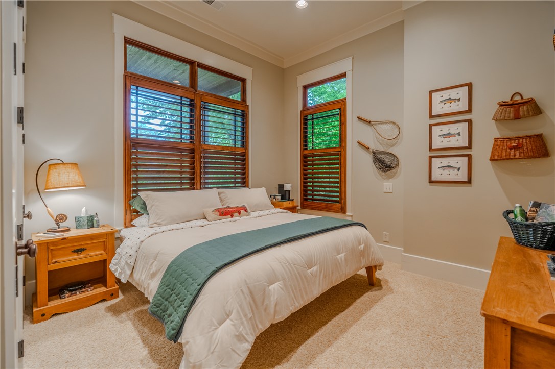 102 State Rd S-39-143 Sunset, SC 29685 - Photo 36 of 47 This cozy bedroom features warm wooden shutters and plush carpeting, creating a serene and inviting atmosphere.