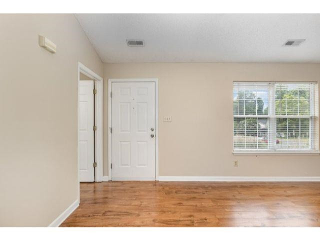 608 Perry Howard Road Fuquay-Varina, NC 27526 - Photo 3 of 21 a view of an empty room with wooden floor and a window