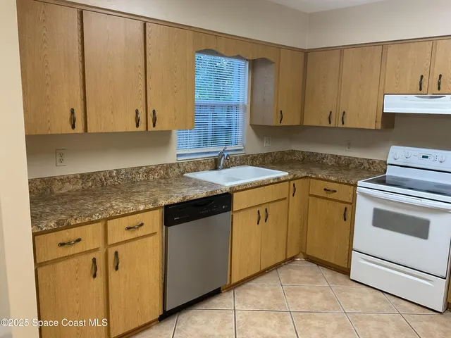 a kitchen with granite countertop cabinets sink and stove top oven