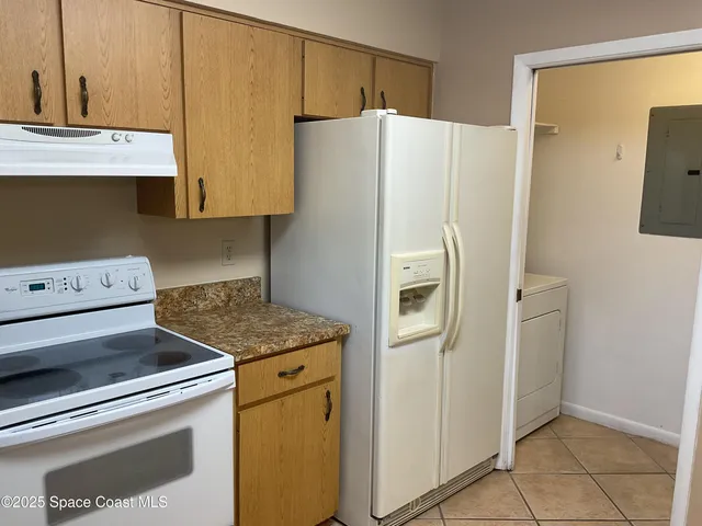 a white refrigerator freezer and a stove sitting inside of a kitchen