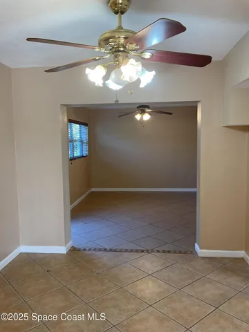 en empty room with wooden floor chandelier and entryway