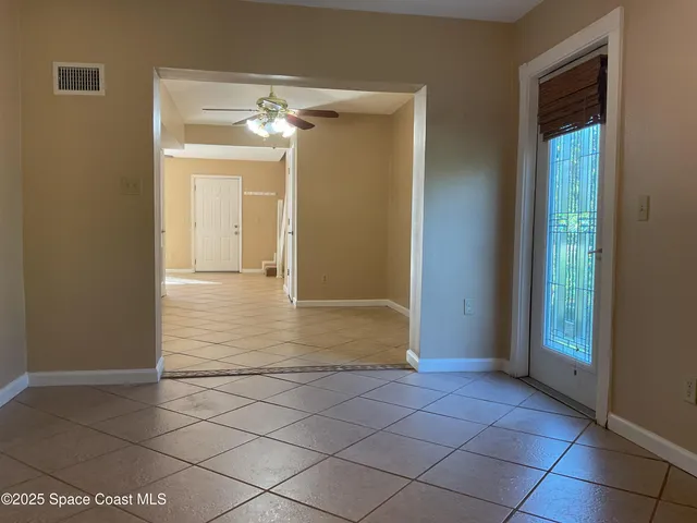 a view of a hallway with wooden floor and a bathroom