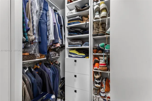 a view of walk in closet with clothes and shoes