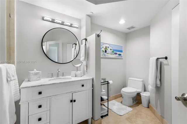 a bathroom with a toilet a sink a mirror and a shower