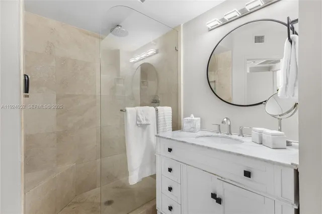 a bathroom with a sink vanity granite and a mirror